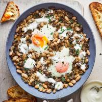 Baked eggs with beans, mushrooms, tarragon & crème fraîche image