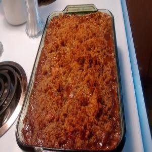 Baked beans and hot dogs with bread crumb topping. image