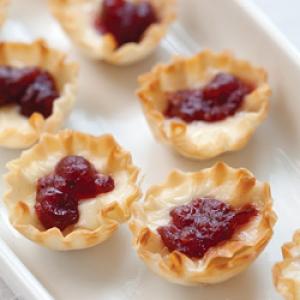 Brie and Cranberry Tartlets Brie and Cranberry Tartlets Makes 45 tartlets 3 (1.9-ounce) packages miniature phyllo pastry shells (45 shells)* 1 cup whole-berry cranberry sauce 1 tablespoon orange zest _image