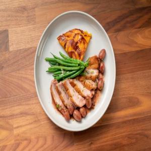 Seared Duck Breast with Roasted Grape and Port Wine Sauce with Sweet Potato Cake and Sautéed Haricot Verts image
