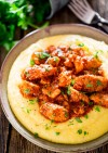 saucy-chicken-and-sausage-over-creamy-parmesan-polenta image