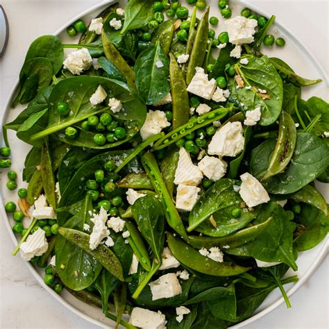 warm-spinach-salad-with-feta-and-peas-simply-delicious image