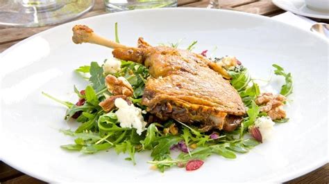 duck-confit-salad-with-arugula-dried-cherries-blue image