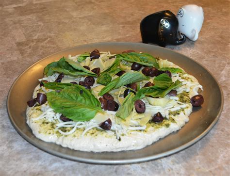 pesto-pizza-with-artichoke-black-olives-basil image