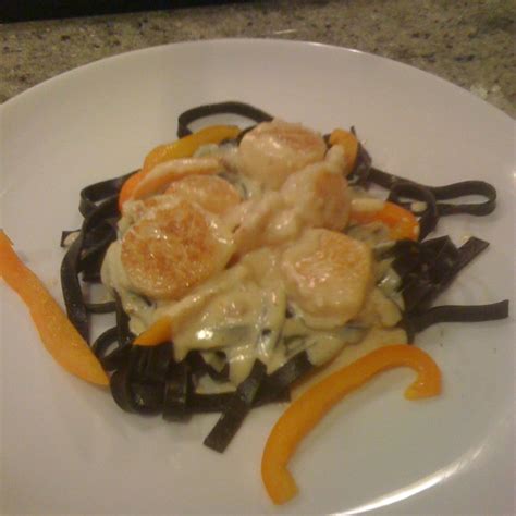 shrimp-and-scallops-in-saffron-cream-with-black-pasta image