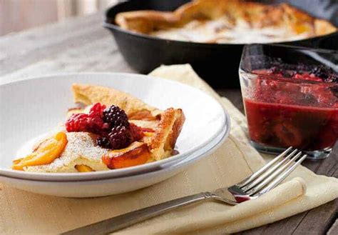 fresh-peach-dutch-baby-recipe-with-berry-topping-macheesmo image