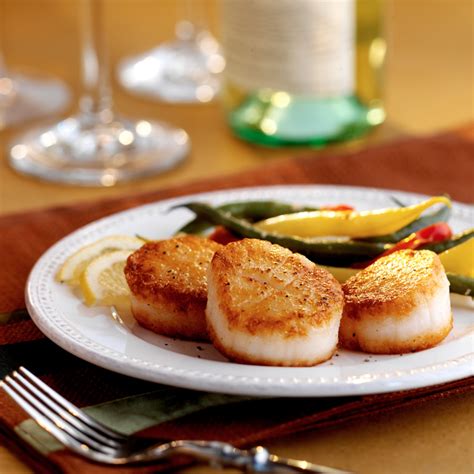 seared-sea-scallops-on-a-bed-of-sauted-greens image