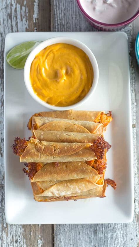 baked-taquitos-with-creamy-salsa-and-guacamole-the image