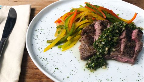 skirt-steak-with-chimichurri-mixed-peppers-and-onions image