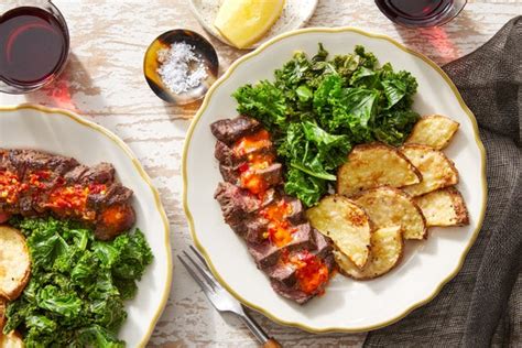 seared-steaks-garlic-kale-with-cheesy-roasted-potatoes image