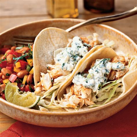fish-tacos-with-lime-cilantro-crema-recipe-myrecipes image
