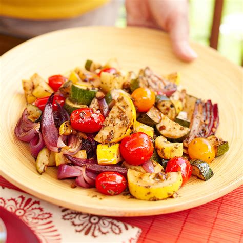 grilled-summer-squash-onions-and-tomatoes-eatingwell image