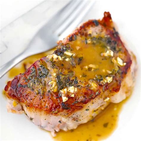 juicy-oven-baked-pork-chops-with-garlic-lemon-and-herbs image