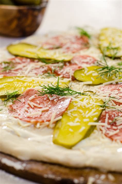dill-pickle-pizza-with-crispy-salami-food-above-gold image