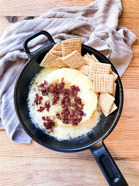 baked-brie-with-sun-dried-tomatoes-and-roasted-garlic image