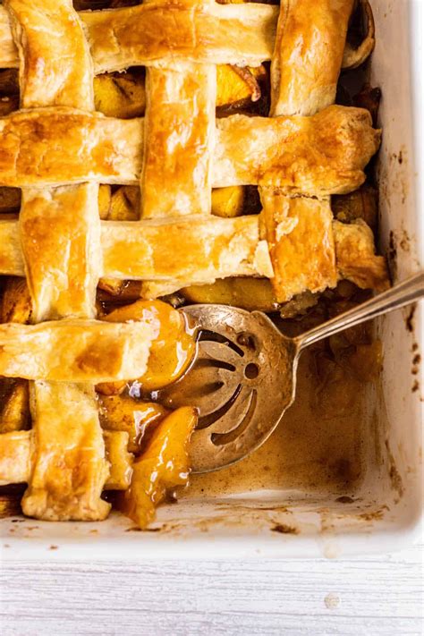 peach-cobbler-with-pie-crust-baking-with-butter image