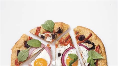pizza-with-eggs-roasted-red-peppers-olives-and-arugula image