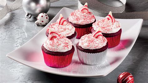 santa-hat-topped-red-velvet-cupcakes image
